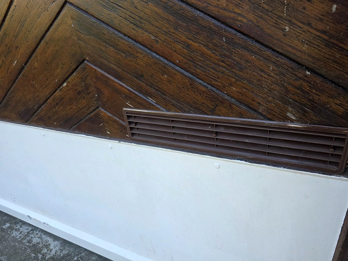 Une grille posée en bas de la porte du garage : l’air rafraîchi par l’appareil, plus lourd, peut sortir, et de l’air neuf entre.