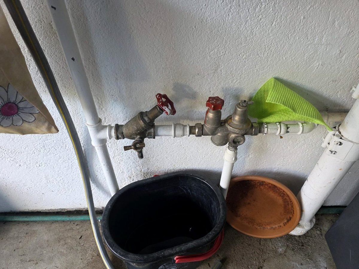 Avant les travaux : la vanne d’arrêt et le groupe de sécurité d’origine, sur l’arrivée d’eau froide du chauffe-eau. Le seau en dessous disait déjà quelque chose.