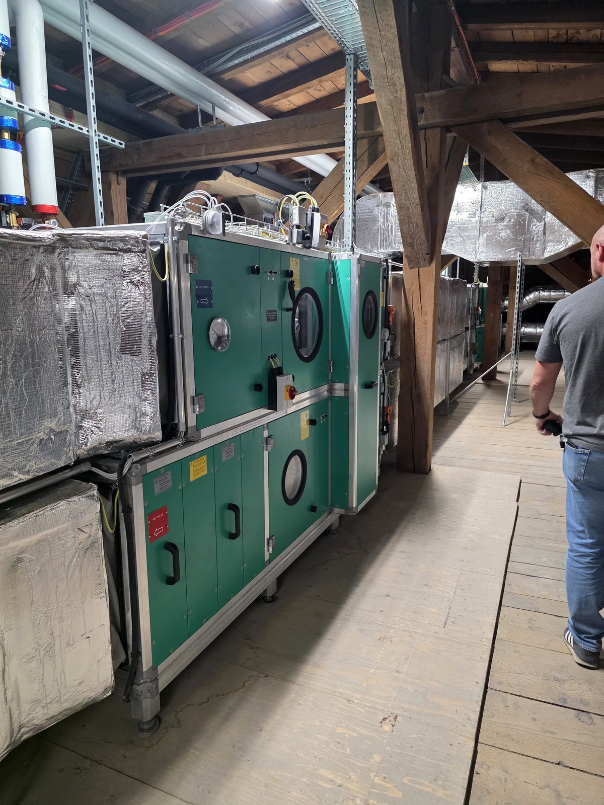 Technicien ouvrant le caisson d'un monobloc de ventilation lors d'un dépannage, bornier et câblage visibles