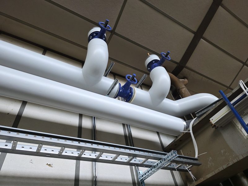 Distribution de chauffage neuve, conduites calorifugées et vannes papillon dans un bâtiment collectif
